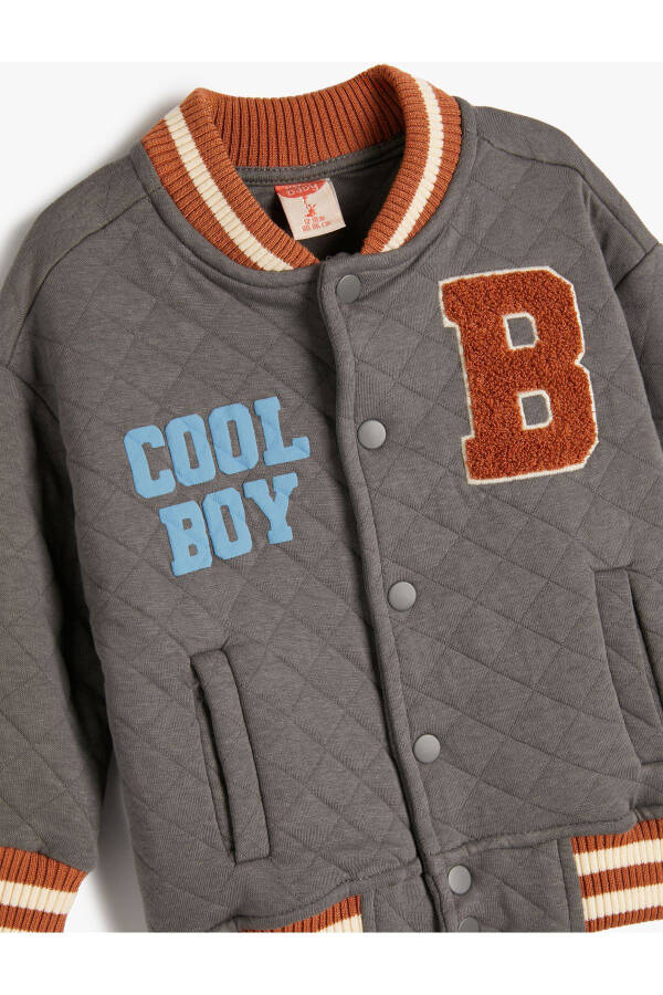 College jacket with quilted details, printed pockets and snap closure. - 6