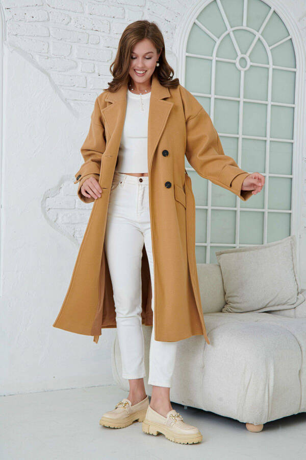 Double-breasted, buttoned, belted, long-sleeved, dropped shoulder, lined midi length camel coat. - 7