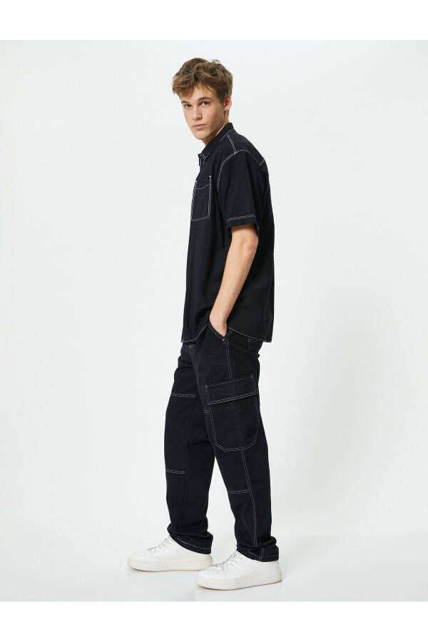 Oversized denim pants with cargo pockets, stitch detailing and buttons. - 9