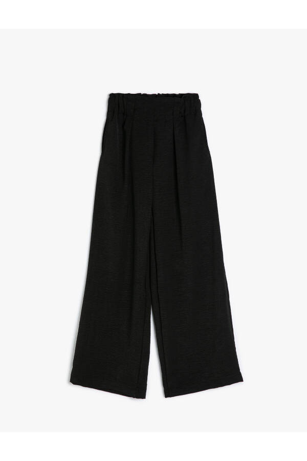 Palazzo pants with wide legs, elastic waistband and button details. - 5