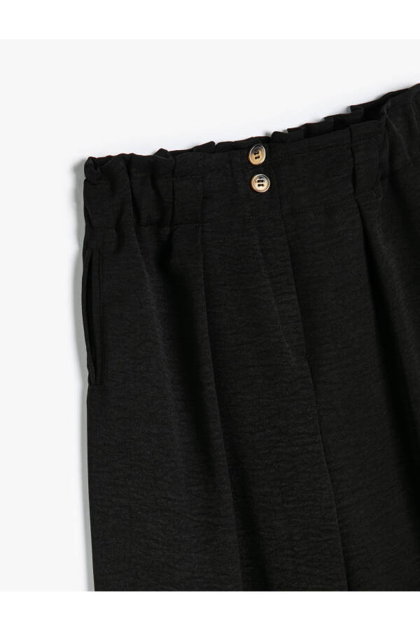 Palazzo pants with wide legs, elastic waistband and button details. - 6